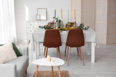 Mumlarla dolu masa ve ışık odasında güzel bir çiçek dekoru.