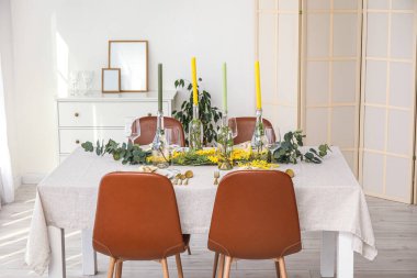 Mumlarla dolu masa ve ışık odasında güzel bir çiçek dekoru.