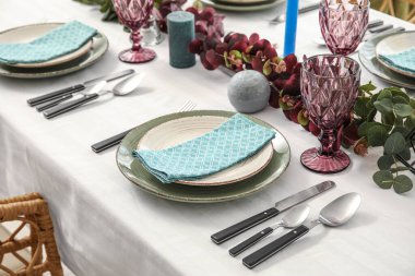 Yemek masasında okaliptüs dalları olan güzel bir ortam.