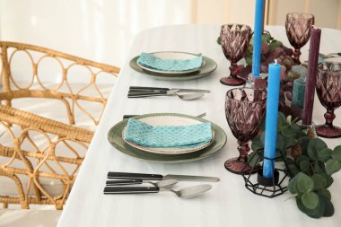 Güzel okaliptüs dalları ve servis edilen mumlarla süslü bir ortam.