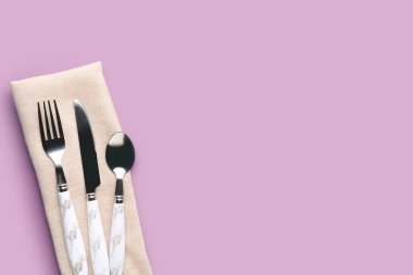 Leylak arkaplan peçeteli gümüş çatal bıçak.