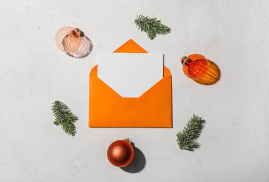 Boş kartlı zarf, beyaz arka planda noel dalları ve toplar