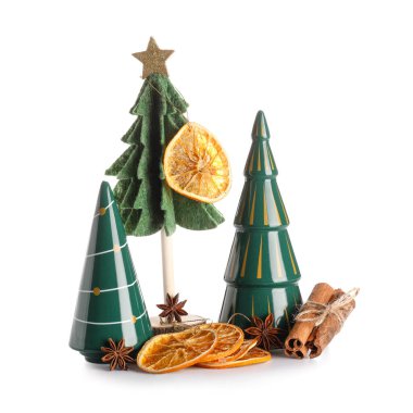 Dekoratif Noel ağaçları, beyaz arka planda kurutulmuş portakal dilimleri ve baharatlar.