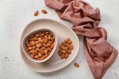 Beyaz arka planda bir kase badem.