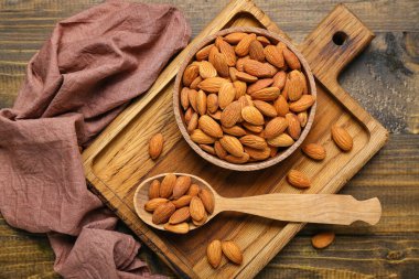 Ahşap zemin üzerinde bir kase badem olan tahta.