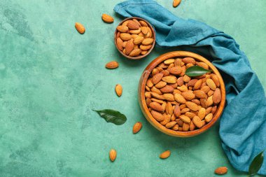 Yeşil arka planda bir kase badem.