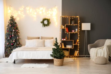 Yatak odasının içinde Noel ağaçları ve parlayan ışıklar var.