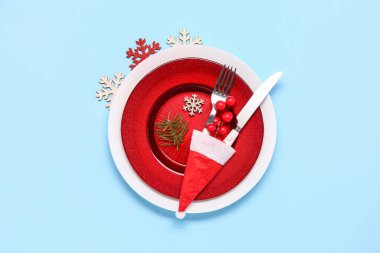 Masa dekorlu ve mavi arka planda Noel Baba şapkalı.