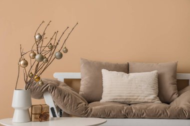 Ağaç dallı vazo, Noel baloları ve oturma odasındaki masada hediye.