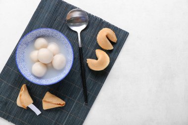 Bambu hasırı, bir kase tangyuan ve beyaz arka planda kurabiyeler. Dongzhi Festivali