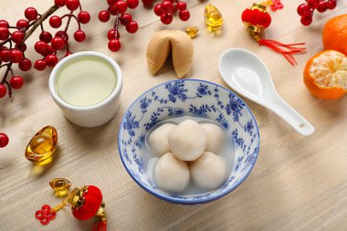 Bir kase tangyuan, kupa, fal kurabiyesi ve ahşap arka planda Çin dekoru. Dongzhi Festivali