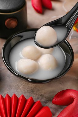 Arka planda bir kaşık ve bir kase tangyuan, yakın plan. Dongzhi Festivali