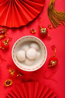 Kırmızı arka planda Çin dekoru olan bir kase tangyuan. Dongzhi Festivali