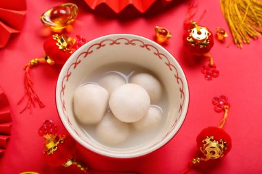 Kırmızı arka planda Çin dekoru olan bir kase tangyuan. Dongzhi Festivali
