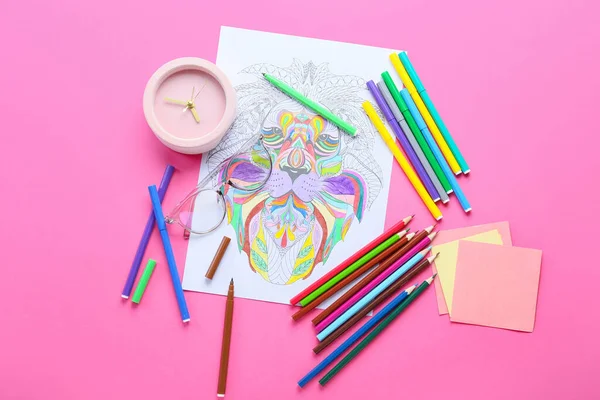 Coloring page, felt-tip pens, pencils, sticky notes and alarm clock on pink background
