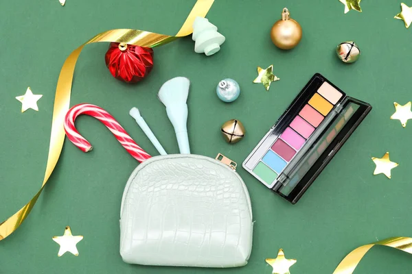 化粧品と化粧品バッグ 緑の背景にキャンディー杖とクリスマスの装飾 — ストック写真