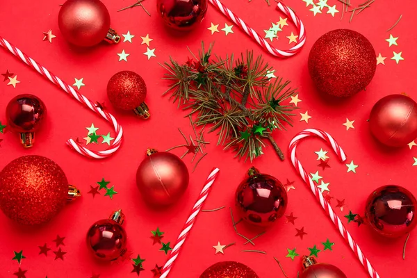 Samenstelling Met Kerstballen Snoepgoed Lovertjes Rode Achtergrond — Stockfoto