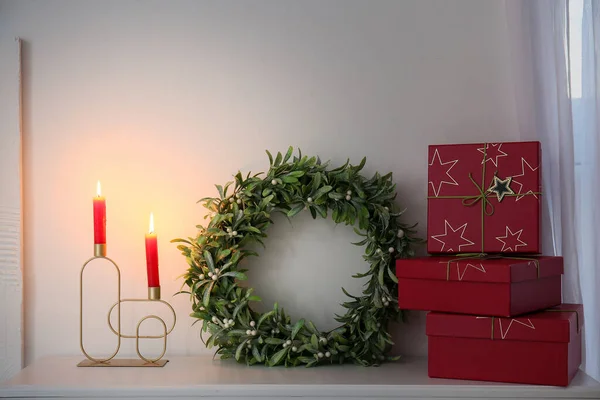 Рождественский Венок Омелы Подарками Свечами Камине Возле Светлой Стены — стоковое фото