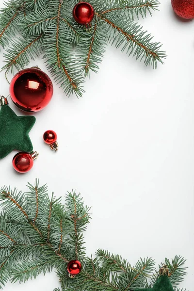 白い背景にモミの枝とクリスマスの装飾で作られたフレーム トップビュー — ストック写真