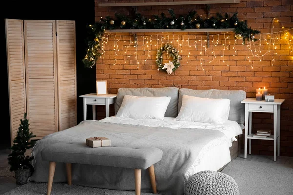 クリスマスリース モミの枝と輝く照明付きの寝室のインテリア — ストック写真