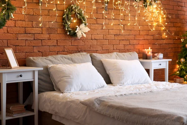 クリスマスリースと輝く照明付きの寝室のインテリア — ストック写真