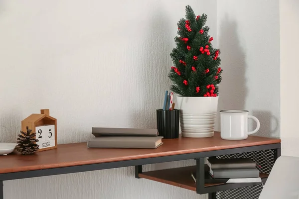 小さなクリスマスツリーと光の壁の近くのカレンダーを持つ職場 — ストック写真