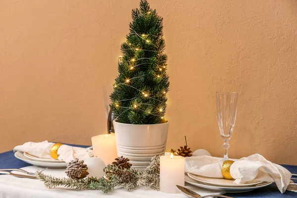 Tischdekoration Mit Kleinem Weihnachtsbaum Tannenzapfen Und Kerzen Nahe Beiger Wand — Stockfoto