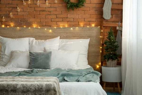 クリスマスツリーと輝く照明付きの寝室のインテリア — ストック写真