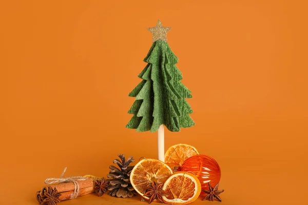 stock image Felt Christmas tree, spices, ball and dried orange slices on color background