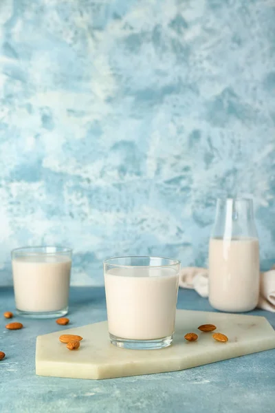 健康的なアーモンドミルクのガラスと色の背景にボード — ストック写真