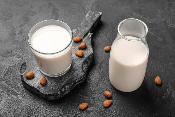 Koyu Arkaplanda Cam Bir Şişe Badem Sütü Olan Tahta — Stok fotoğraf