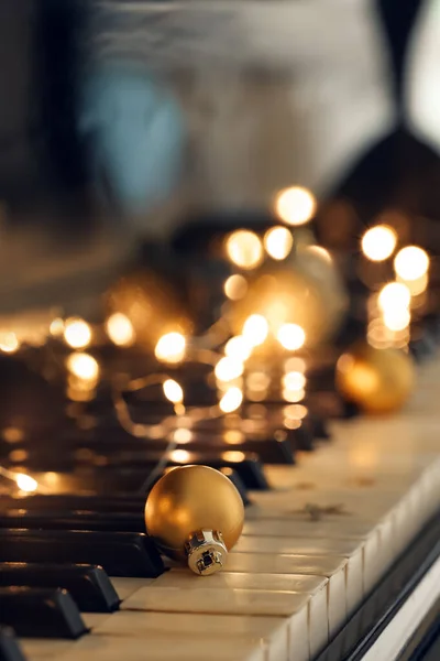Christmas Ball Glowing Lights Piano Keys Closeup — Stock Photo, Image