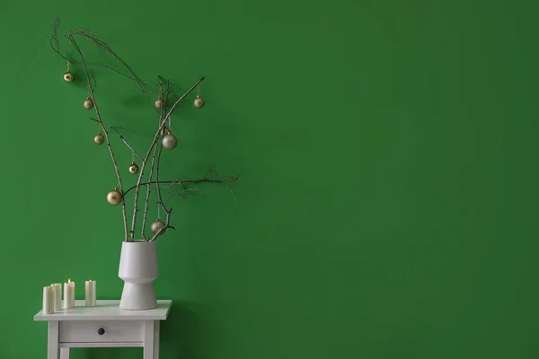 Ваза Гілками Дерев Ялинковими Кульками Свічками Столі Біля Зеленої Стіни — стокове фото