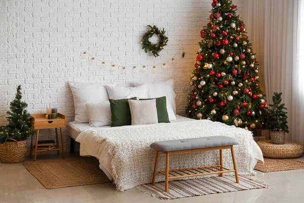 Interior of bedroom with Christmas trees and wreath