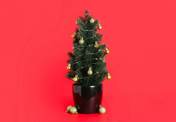 Kleiner Weihnachtsbaum Mit Kugeln Und Leuchtenden Lichtern Auf Rotem Hintergrund — Stockfoto