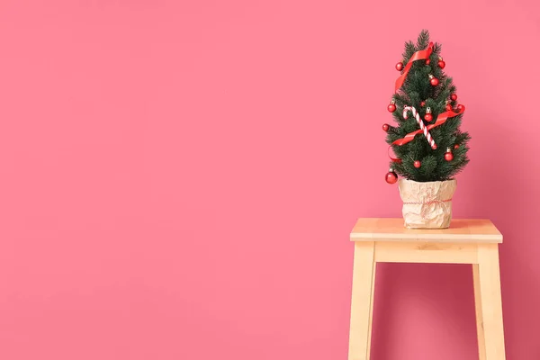 Μικρό Χριστουγεννιάτικο Δέντρο Σκαμνί Κοντά Στον Κόκκινο Τοίχο — Φωτογραφία Αρχείου