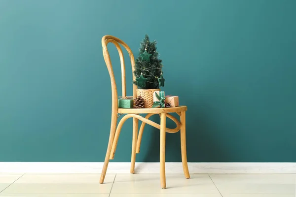 Μικρό Χριστουγεννιάτικο Δέντρο Κουκουνάρια Και Δώρα Στην Καρέκλα Κοντά Πράσινο — Φωτογραφία Αρχείου