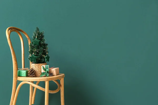 Kis Karácsonyfa Fenyőtobozokkal Ajándékokkal Széken Zöld Fal Közelében — Stock Fotó