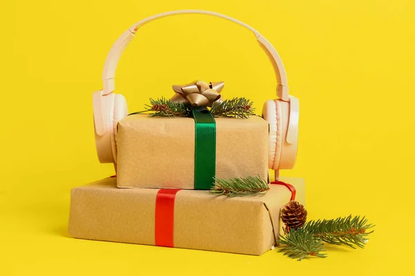Headphones Christmas Gifts Fir Branches Yellow Background — Stock Photo, Image