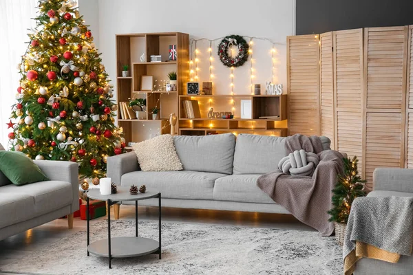 ソファ クリスマスツリーと輝く照明付きのリビングルームのインテリア — ストック写真