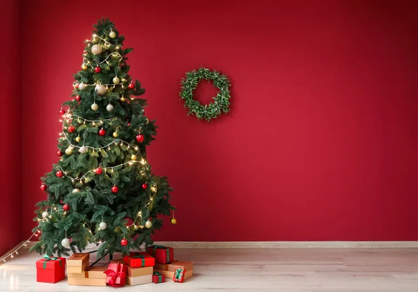 Árbol Navidad Brillante Con Regalos Corona Pared Roja —  Fotos de Stock