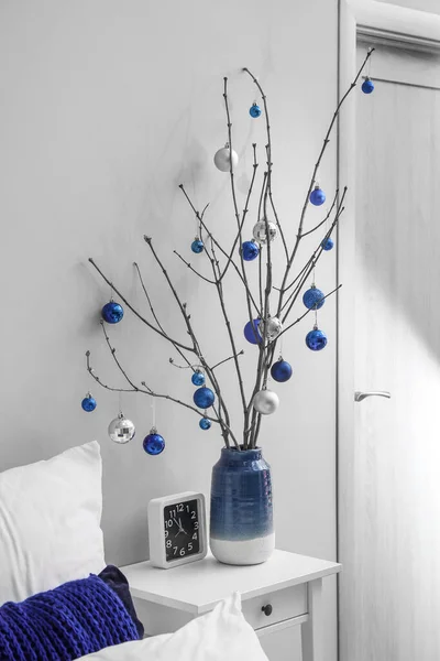 木の枝 クリスマスボールとベッドルームでテーブルの上のクロックと花瓶 — ストック写真