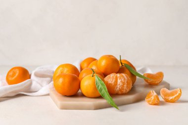 Açık arkaplanlı taze olgun mandalinalı tahta