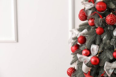 Işık duvarının yanındaki dekore edilmiş Noel ağacı, yakın plan.