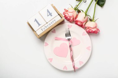 14 Şubat tarihli küp takvimi, masa ayarları ve beyaz arkaplanda güller