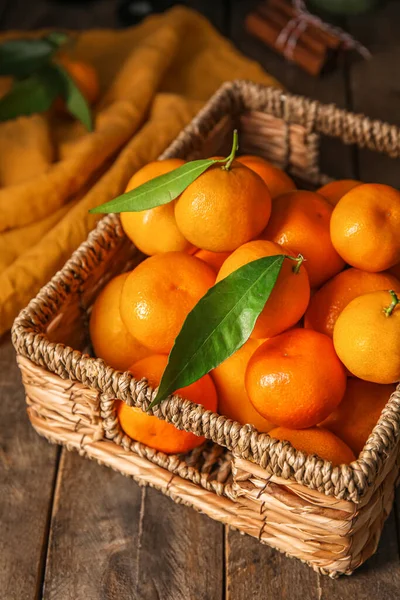 stock image Basket with ripe tangerines on wooden table, closeup