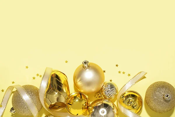 Golden Christmas Balls Bells Ribbon Yellow Background — Stock Photo, Image