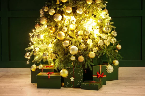 Ragyogó Karácsonyfa Ajándékokkal Közel Zöld Fal — Stock Fotó