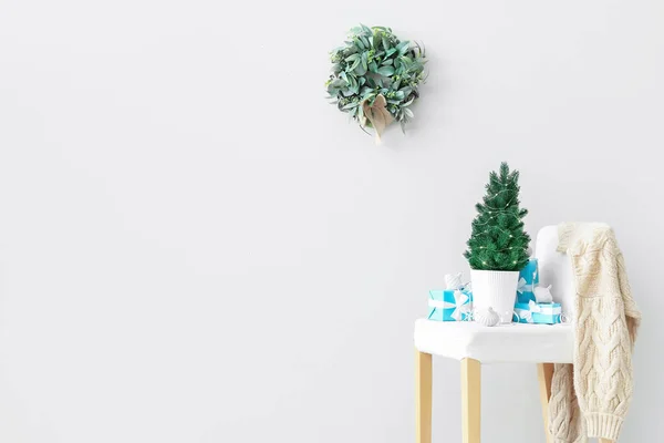 Işık Duvarının Yanındaki Sandalyede Hediyeleri Olan Küçük Noel Ağacı — Stok fotoğraf