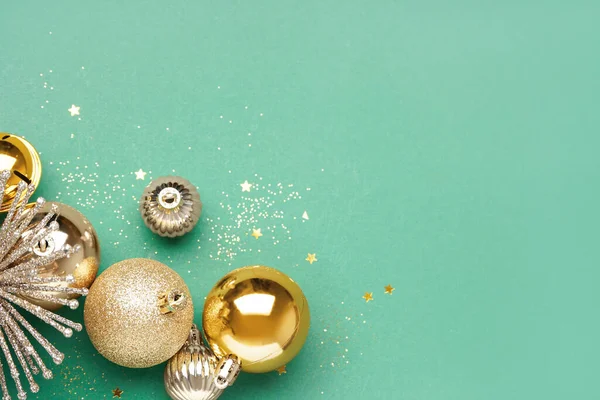 緑の背景にキラキラと金色のクリスマスボール — ストック写真